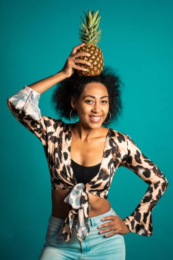 Kafasında taze ananas olan Afro-Amerikan bir kadın. Sağlıklı egzotik yaşam tarzı ve yeme konsepti. 