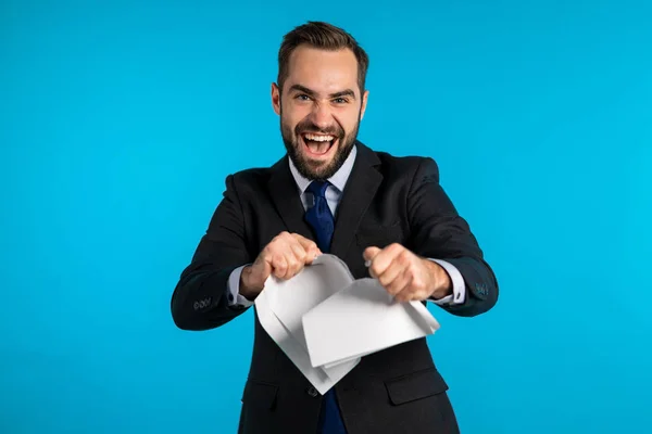 Um homem de negócios sério a rasgar um contrato em pedaços. Irritado furioso trabalhador de escritório masculino jogando papel amassado, tendo colapso nervoso no trabalho, gritando de raiva, gerenciamento de estresse . — Fotografia de Stock