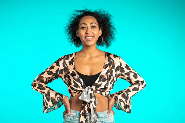 Mulher muito africana com cabelo afro no topo do leopardo sorrindo para a câmera sobre fundo de parede azul. bonito misto raça meninas retrato . — Fotografia de Stock