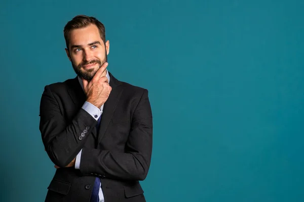 Positiv denkender Geschäftsmann, der auf blauem Hintergrund auf- und umblickt. Zufriedene Mienen. gutaussehendes männliches Modell im Wahlkampfanzug. Kopierraum. — Stockfoto