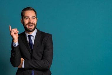 Pozitif düşünen iş adamı mavi arka planda etrafa bakıyor. Mutlu yüz ifadeleri. Kampanya elbisesi içindeki yakışıklı erkek model..