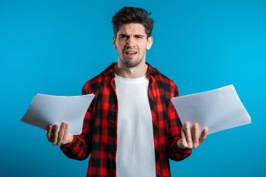 Mavi arka planda ciddi bir işadamı patronu. Tatmin olmamış, endişeli ve personel işleriyle kafası karışık. Genç bir erkek ofis çalışanı evrakları kontrol ediyor.