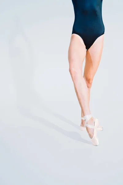 Zbliżenie baletowe nogi tancerki w Pointe. Kobieta praktyki ćwiczenia na białym tle Studio. Ballerinas stopy w butach. Dziewczyna pokazuje klasyczne balet. — Zdjęcie stockowe