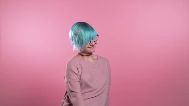 Mulher incomum com cabelo azul se divertindo, sorrindo, dançando meme moda redes sociais dançar em estúdio contra fundo rosa. Música, conceito de dança, câmera lenta . — Vídeo de Stock