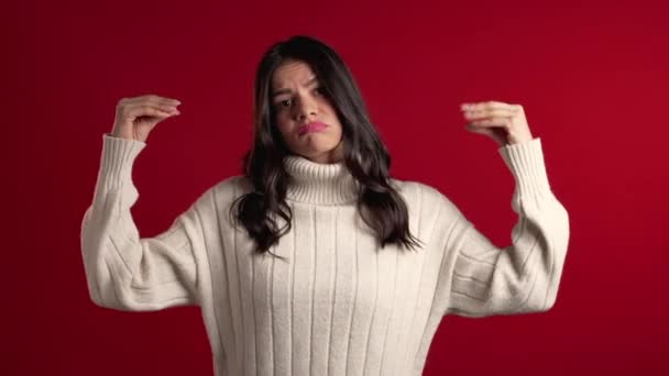 Cute latin woman showing bla-bla-bla gesture with hands and rolling eyes isolated on red background. Empty promises, blah concept. Lier. — 비디오