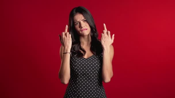 Mladá hezká žena na červeném pozadí ukazující prostředníček - gesto šukání. Výraz negativní, agresivní, provokativní. — Stock video