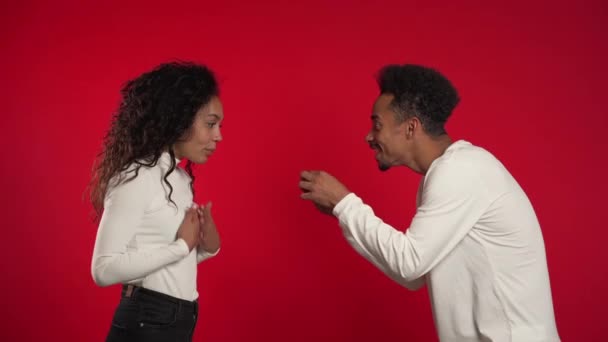 Νεαρό ζευγάρι. Αφρικανός κάνει πρόταση γάμου στην ερωμένη του με δαχτυλίδι στο κόκκινο φόντο του στούντιο. Αγάπη, διακοπές, ευτυχία. — Αρχείο Βίντεο