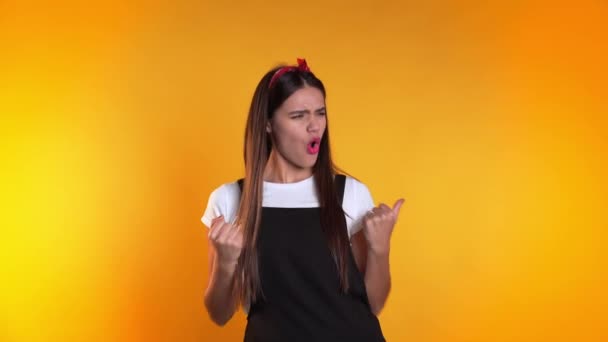 Surprised excited happy woman on yellow background. Girl with long hair shows yes gesture of victory,she achieved result, goals. — Stok video