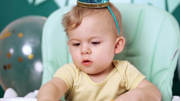 Bébé garçon mignon assis sur sa chaise et jouant avec des briques colorées. Anniversaire beau tout-petit enfant avec de grands yeux portrait. Drôle de gamin . — Video