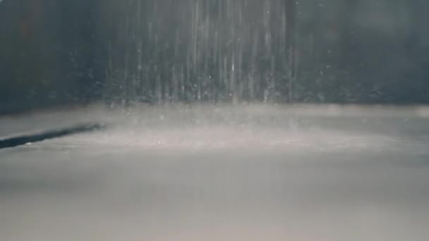 Falling water and drops in front of camera from shower head at bathroom grey interior, close-up. Nobody. — Stok video