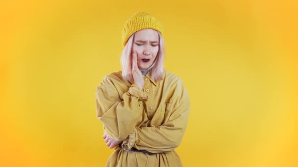 Young pretty woman with tooth pain on yellow studio background. Toothache, dental problems, stomatology and medicine concept — Stock Video