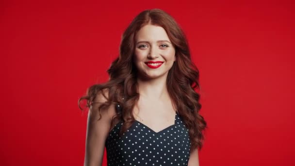 Mladá kudrnatá žena v retro stylu. Portrét flirtování krásná dívka na červeném pozadí stěny studio. — Stock video