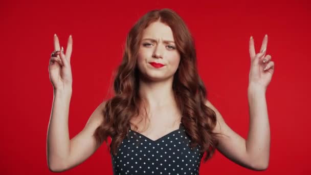Csinos lány mutatja a kezét, és két ujját, mint egy idézet gesztus, hajlítsa ujjak elszigetelt piros háttér. Nagyon vicces, ironikus és szarkazmus koncepció. — Stock videók