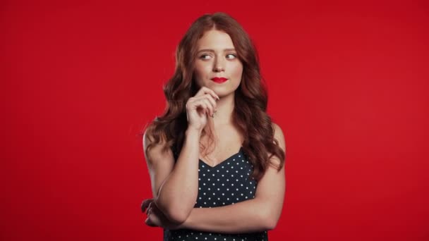 Thinking woman looking up and around on red background. Worried contemplative face expressions. Pretty girl model with retro styled appearance. — Stockvideo