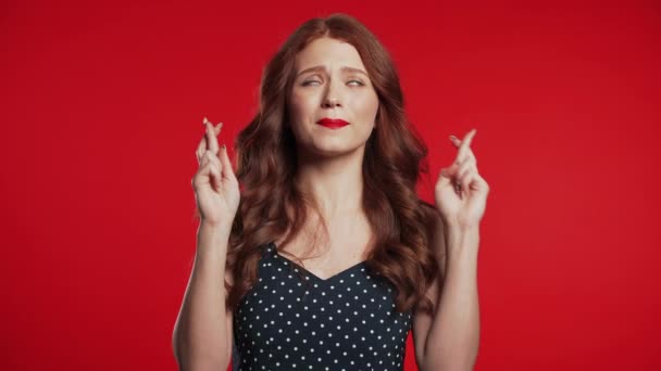 Nettes junges Mädchen mit roter Frisur, das vor Studiohintergrund betet. Frau bettelt jemanden an. 4k. — Stockvideo