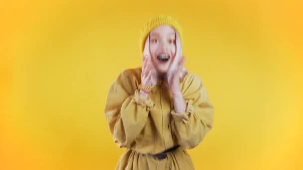 Portrét dívky s růžovými vlasy, ukazuje wow potěšení efekt gesto. Překvapená vzrušená šťastná žena. Hezká žena šokovaný model na žlutém pozadí. — Stock video