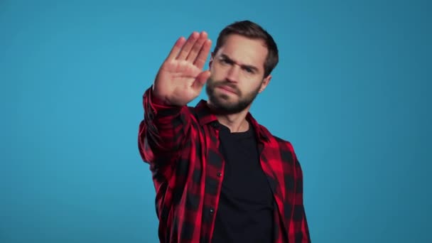 No, never, handsome brunette man disliking and rejecting gesture by stop sign. Portrait of young successful confident guy isolated on blue — Stock Video