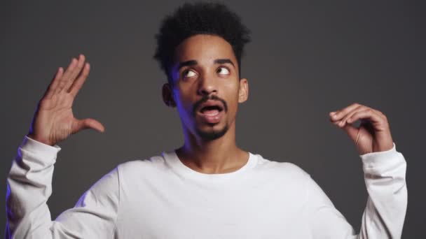 Handsome african man showing bla-bla-bla gesture with hands and rolling eyes isolated on grey background. Empty promises, blah concept. Lier. — Stock Video