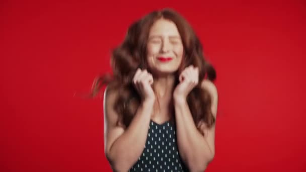 Kızıl saçlı kız çok mutlu ve mutlu, gülümsüyor, çığlık atıyor ve zıplıyor. Stüdyo arka planında heyecanlı, mutlu bir kadın. — Stok video