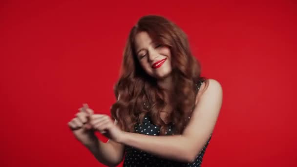 Όμορφη γυναίκα με όμορφα μαλλιά αστείο χορό σε κόκκινο φόντο στούντιο. Ωραίο πορτρέτο κοριτσιών. Κόμμα, ευτυχία, ελευθερία, έννοια της νεολαίας. — Αρχείο Βίντεο