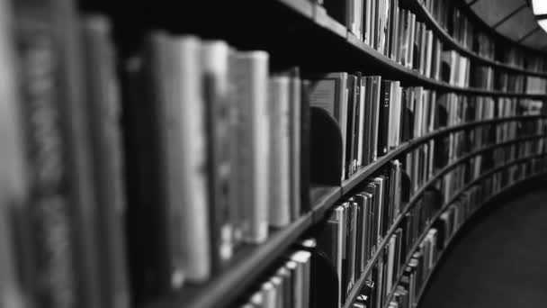 스 테디 엄 샷. 카메라는 종이 책으로 가득 찬 책꽂이를 따라 뒤로 이동 한다. 흑백 화면입니다. 스웨덴 스톡홀름에 있는 거대 한 둥근 도서관 — 비디오