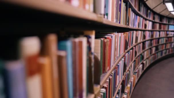 Stehaufmännchen erschossen. Die Kamera bewegt sich an Regalen entlang, die mit Papierbüchern gefüllt sind. Die riesige runde Bibliothek in Stockholm, Schweden — Stockvideo