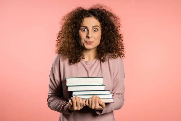 스튜디오의 핑크 배경에 있는 유럽 학생들은 도서관에 있는 대학 교재들을 보유하고 있다. 졸업하고 싶어 하는 여자. — 스톡 사진