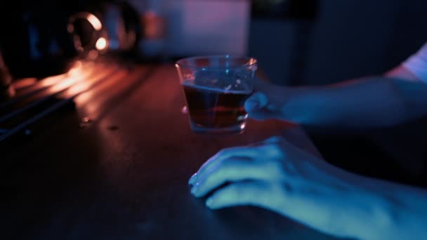 Junge Frau trinkt ein Glas Bier im Neonlicht. Unbekanntes Weibchen nachts mit Alkoholgetränk in Küche. — Stockvideo