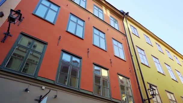 Lägenhet byggnader på europeiska gator i gamla norra staden. Skandinaviska fönster. Fasader av färgglada hus på smala gator i Stockholm. Resekoncept. Sakta i backarna. Steadicam skjuten — Stockvideo