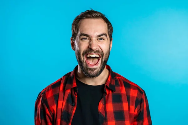 Homem de camisa vermelha muito feliz e feliz, sorrindo, gritando. surpresa animado feliz cara no azul estúdio fundo — Fotografia de Stock