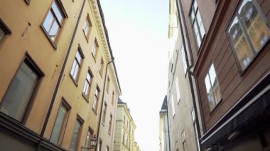 Stockholm bölgesinde kışın apartman binası caddeleri. Dar sokaklardaki eski şehir evlerinin İskandinav cepheleri. Seyahat konsepti. Ağır çekim. Sabit çekim