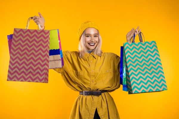 Felice giovane donna con capelli colorati e sacchetti di carta dopo lo shopping isolato — Foto Stock