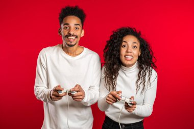 Oldukça genç bir Afrikalı televizyonda video oyunu oynuyor. Kırmızı stüdyo duvarında joystick var. Modern teknolojiyi kullanarak.