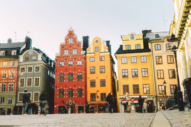 Gamla Stan - Stockholm, İsveç 'in eski bir kasabası. Meydanda turistlerle dolu renkli evler.