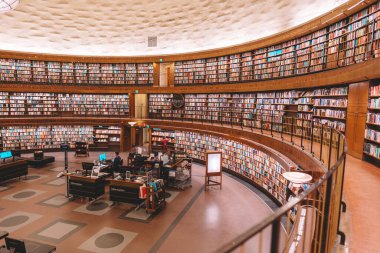 Yuvarlak binadaki raflarda renkli kitaplarla halk kütüphanesi, Stadsbibliotek. 14 Şubat 2020, Stockholm İsveç