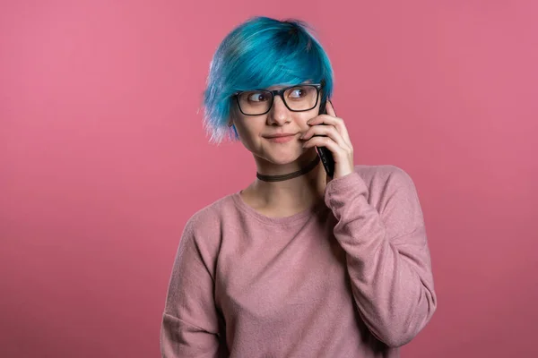 Frau mit blauen Haaren im Gespräch mit jemandem per Handy. Mädchen lächelnd, mit angenehmen Gesprächen. Technologie, mobiles Verbindungskonzept. — Stockfoto