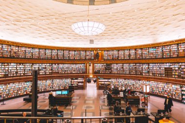 Yuvarlak binadaki raflarda renkli kitaplarla halk kütüphanesi, Stadsbibliotek. 14 Şubat 2020, Stockholm İsveç