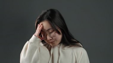 Portrait of young asian woman doing facepalm gesture, like no, I forgot. Unhappy korean woman with long hair feeling sorrow, regret, drama, failure.i She isolated on grey wall