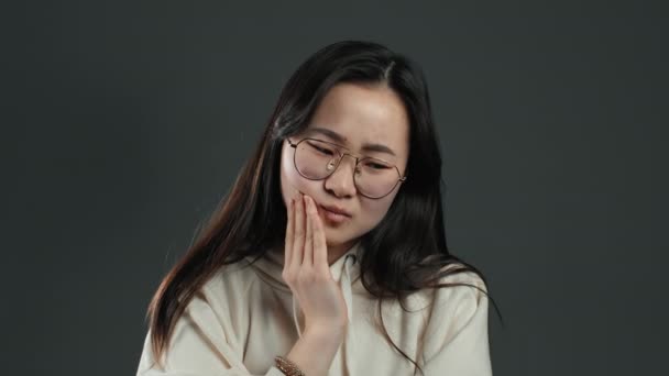 Young asian woman with tooth pain on grey studio background. Toothache, dental problems, stomatology and medicine concept. — Stock Video