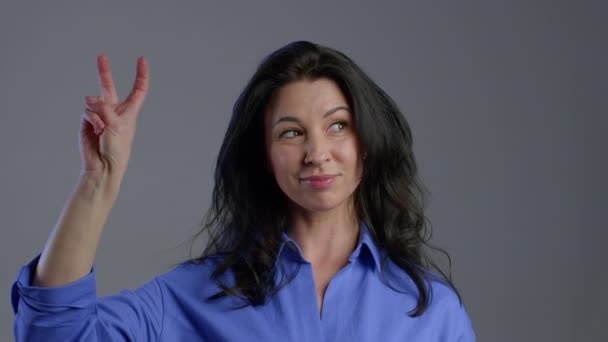 Bella donna mostrando con le mani e due dita come citazioni gesto, piegare le dita isolate su sfondo grigio. Molto divertente, ironia e sarcasmo concetto . — Video Stock