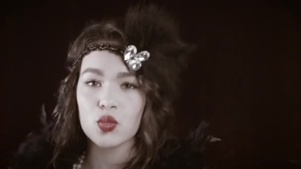 Woman dressed in Great Gatsby era with feathers boa dancing on dark background. Roaring twenties, retro, party, fashion concept. — Stock Video