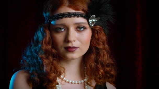 Great Gatsby döneminde giyinmiş eski moda kızıl saçlı bir kadının portresi. Kadife arka planda flört ediyor ve poz veriyor. Kükreyen yirmiler, retro, parti, moda konsepti — Stok video