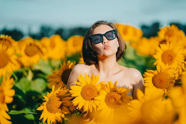 Lustiges Porträt einer nackten Frau mit Sonnenblumen auf der Brust. — Stockfoto