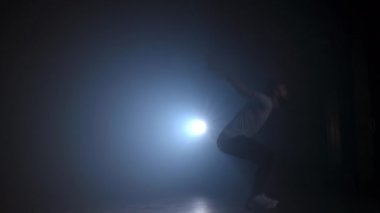 Adamın silueti ağır çekimde ters takla atıyor. Parkour 'da pratik yapan adam. Jimnastik konseptinden fırıl fırıl dönen tekmeler..