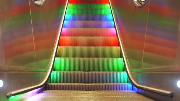 Escalera de cruce peatonal con luces led de arco iris multicolores que se mueven hacia abajo sin fin sin personas. Escaleras automáticas en el metro de Estocolmo — Vídeo de stock