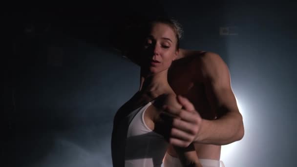 Profesionální, smyslní baletní tanečníci na tmavé scéně v podání sexuálního páru v bílém. Dívají se k sobě s vášní. Láska v očích. Zpomalený pohyb. — Stock video