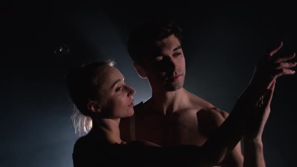 Beyaz elbiseli seksi çift tarafından sahnelenen karanlık sahnede profesyonel, şehvetli bale dansçıları. Birbirinize tutkuyla bakın. Gözlerde aşk. Yavaş çekim. — Stok video