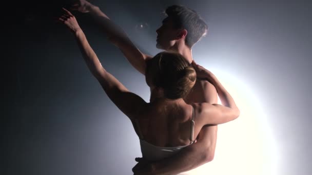 Pareja de ballet profesional romántica practicando movimientos en el escenario oscuro. Pareja joven bailando en vestido clásico, dando vueltas y sonriendo. Graciosidad y ternura en cada movimiento . — Vídeos de Stock