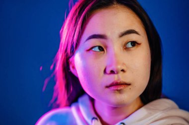 Bin yıllık güzel Koreli kadın portresi. Uzun saçlı, neon ışıklı. Stüdyoda yeniyetme