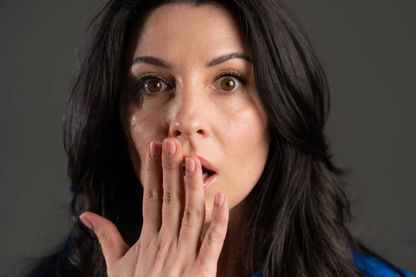 Mature frightened woman shocked isolated over grey background. Stressed and depressed adult lady because of bad news.